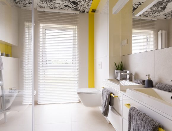 Moderne badkamer design met statement printwand. Gele accentmuur.