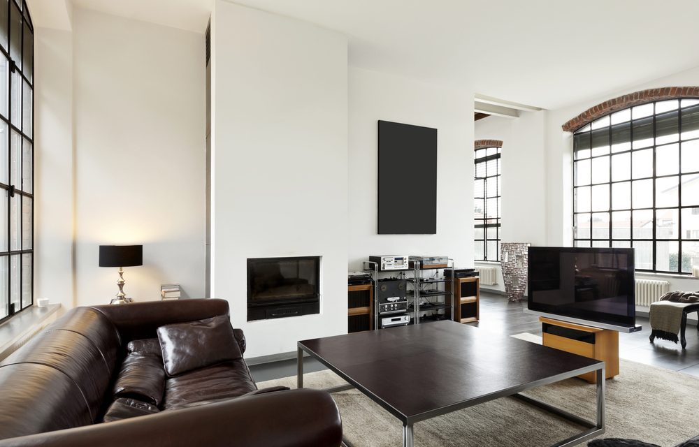 Moderne woonkamer met een spanplafond en bruine lederen zeten. Spanwand met akoestische eigenschappen.