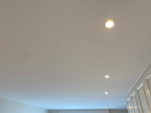 afgewerkt eindresultaat spanplafond met LED verlichting in grote slaapkamer