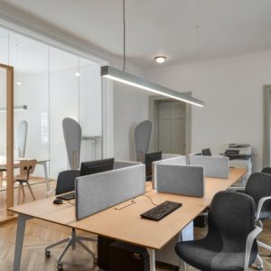 spanplafonds met ronde spots en hang armatuur in een communucatie kantoor