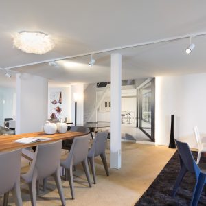 witte spanplafond met railverlichting in moderne showroom